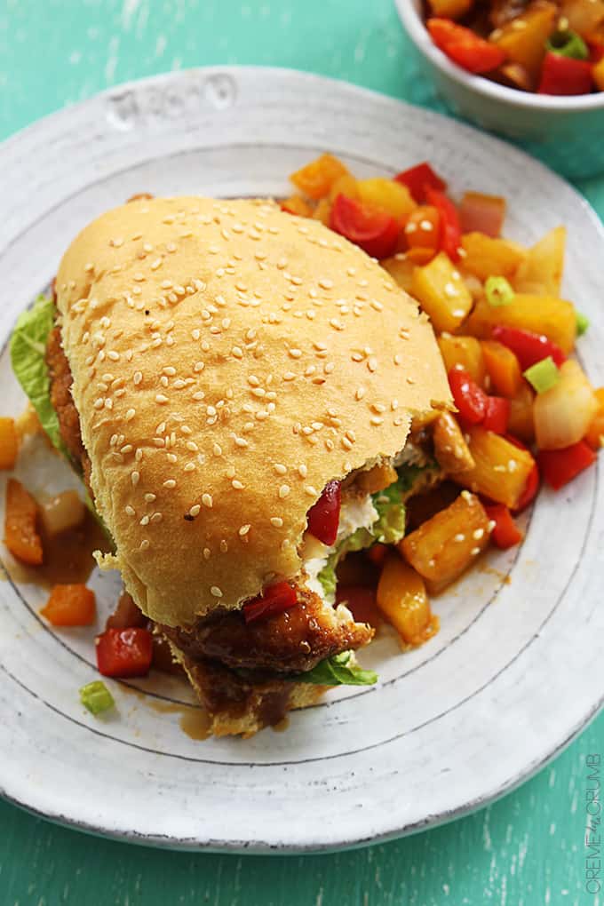 top view of an aloha chicken sandwich on a plate with a bite missing.