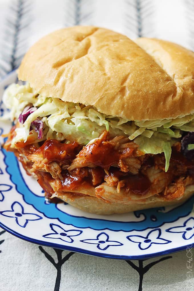 a slow cooker bbq pulled chicken sandwich on a plate.