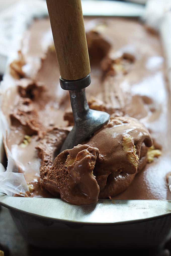 close up of chocolate cookie dough ice cream in a tray with an ice cream scooper.