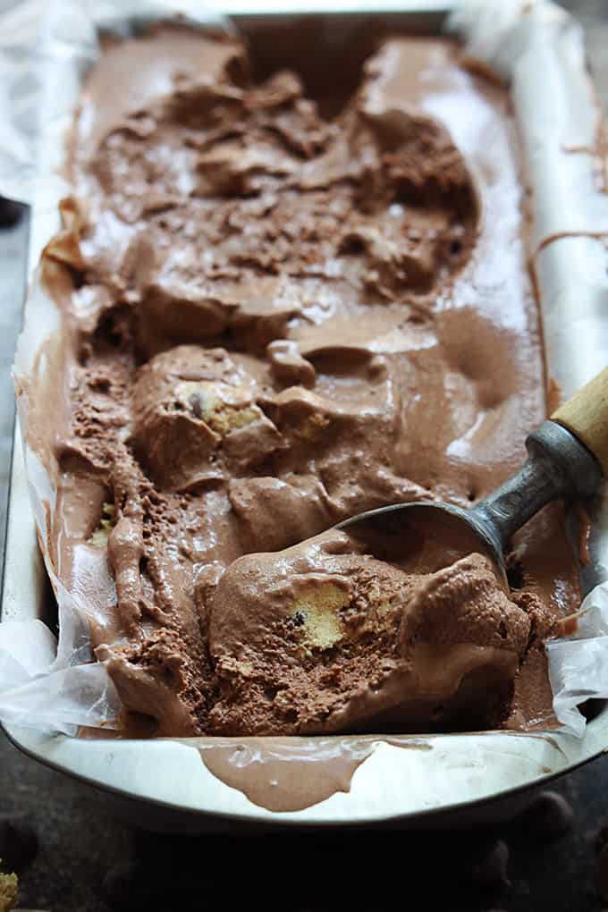close up of chocolate cookie dough ice cream with an ice cream scooper in a tray.