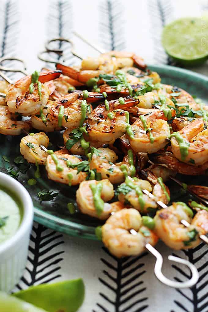 cilantro lime grilled shrimp + roasted poblano sauce on a plate with lime slices.