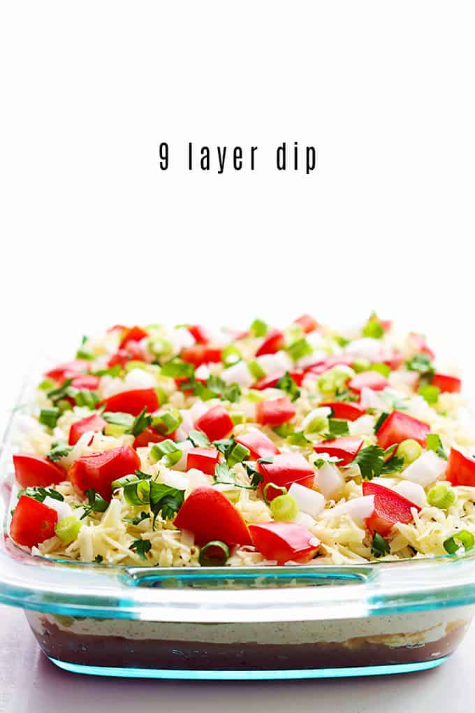 9 layer dip in a tray with the title of the recipe written on the top middle of the image.