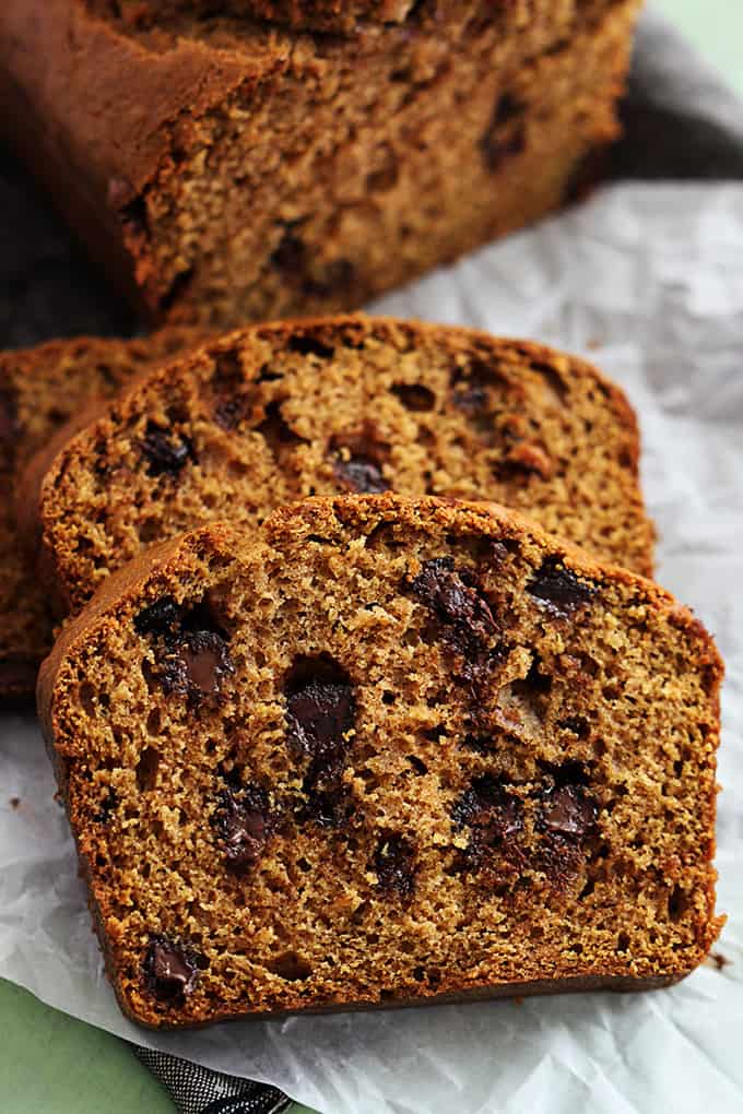 slices of browned butter chocolate chip pumpkin bread with the rest of the loaf in the background.