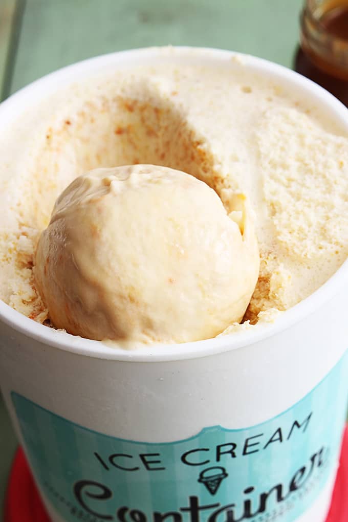 close up of a scoop go butterscotch ice cream in a container of ice cream.