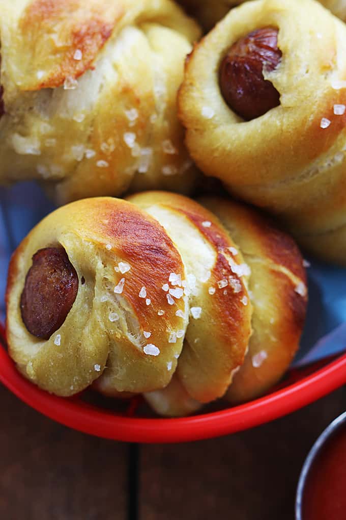 close up of pretzel dogs in a basket.