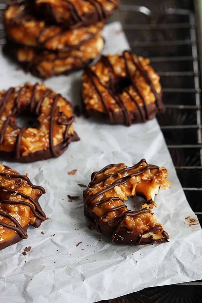 homemade Samoas on a cooling rack with a bite missing out of the front cookie.