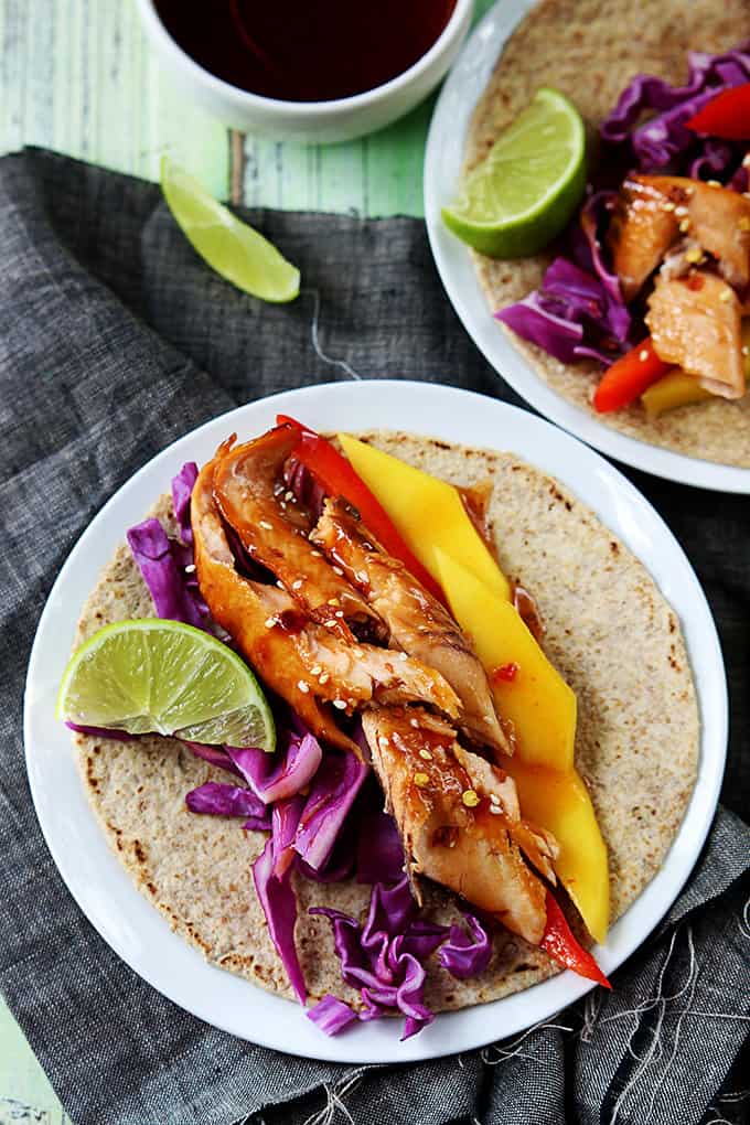 top view of a Thai salmon taco on a plate with another taco on a plate on the side.