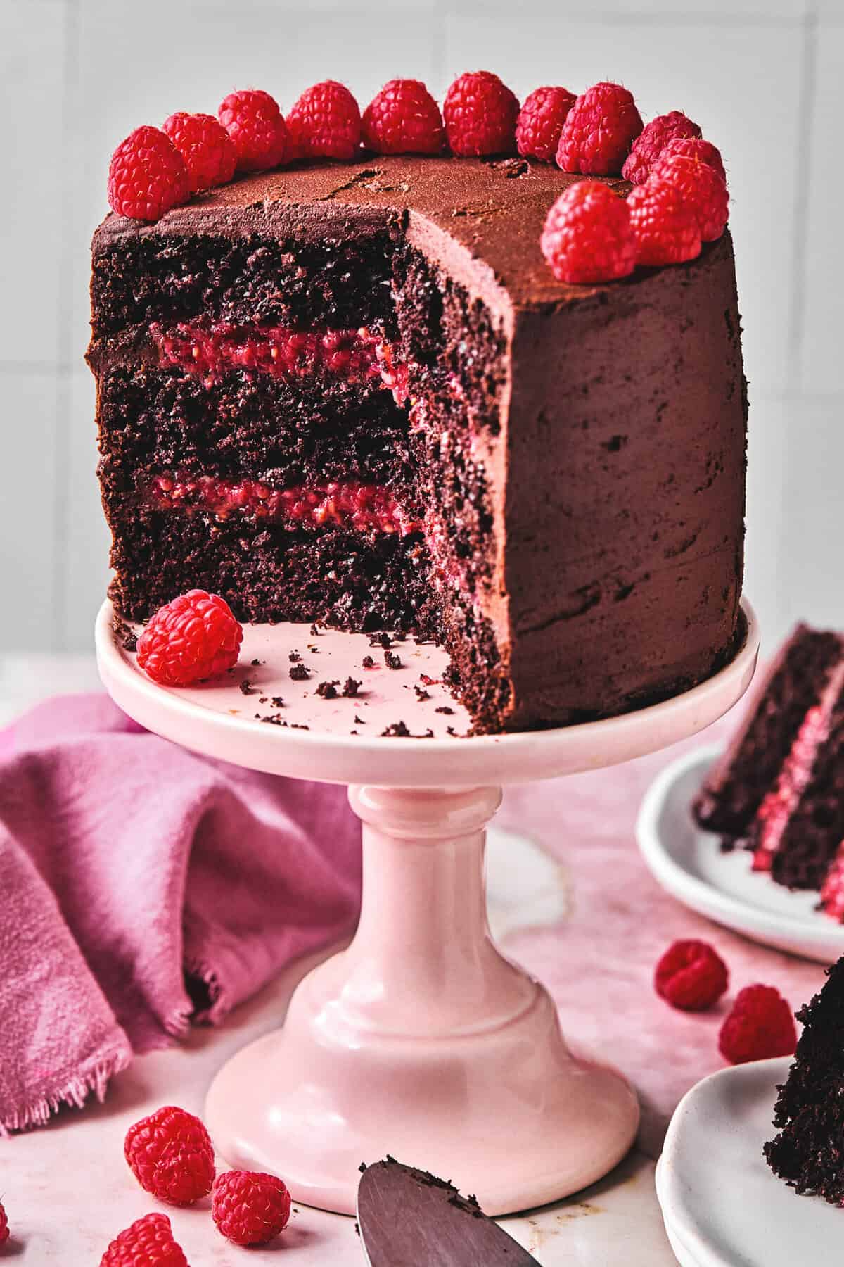 chocolate cake with raspberry filling on cake stand.