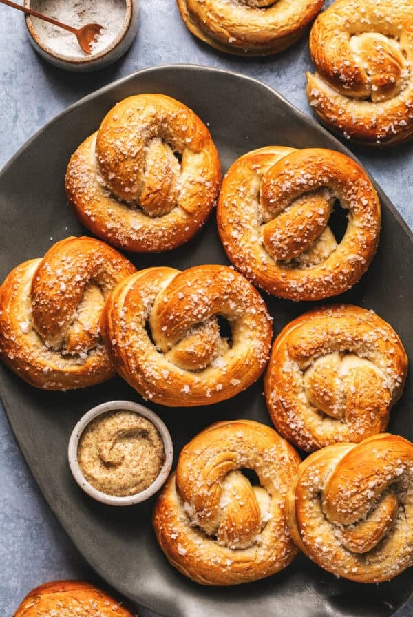 Baked German soft pretzels on serving platter with mustard sauce.