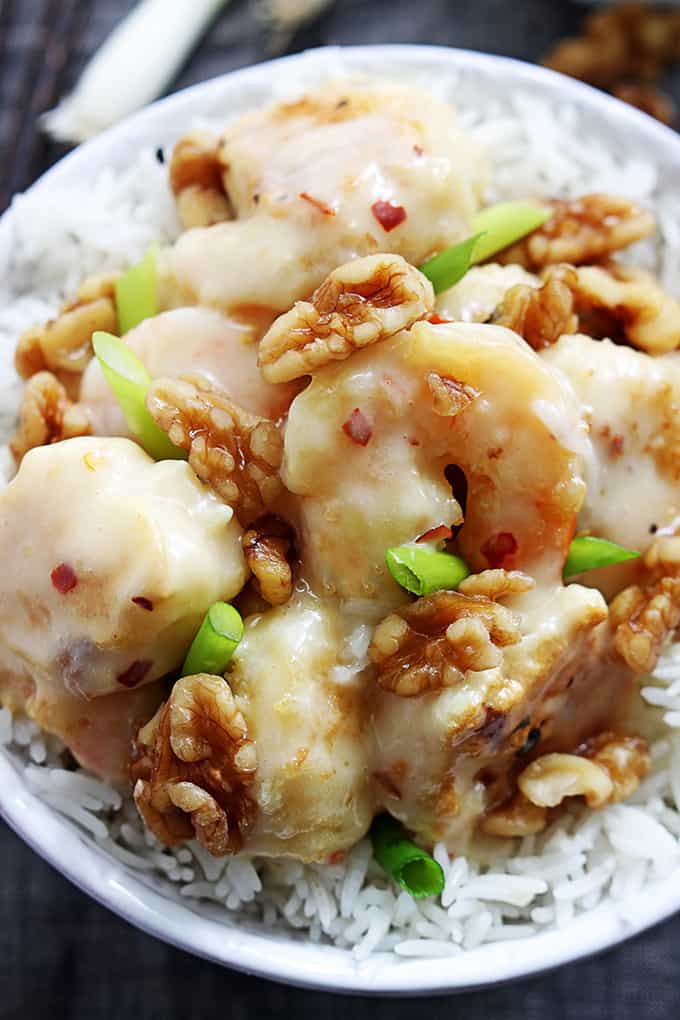 close up top view of honey walnut shrimp on rice in a bowl.
