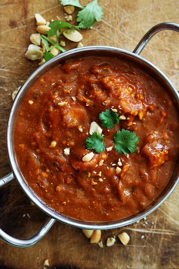 top view of Indian butter chicken on rice in a bowl in a cooking pan.