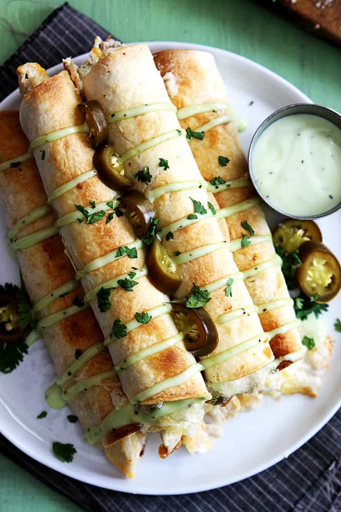 top view of slow cooker jalapeño popper chicken taquitos with sauce on the side.