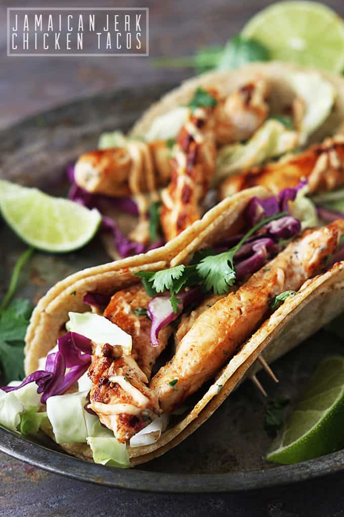 Jamaican jerk chicken tacos on a plate with the title of the recipe written on the top left corner of the image.