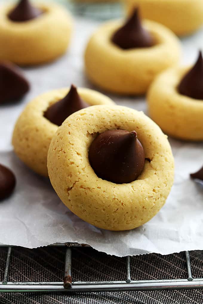 close up of chocolate pumpkin thumbprint cookies on a cooling rack with the front cookie lifted on top of the cookie behind it.