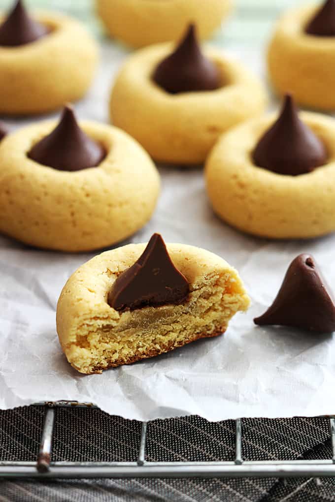 chocolate pumpkin thumbprint cookies on a cooling rack with a half of a cookie in the front.