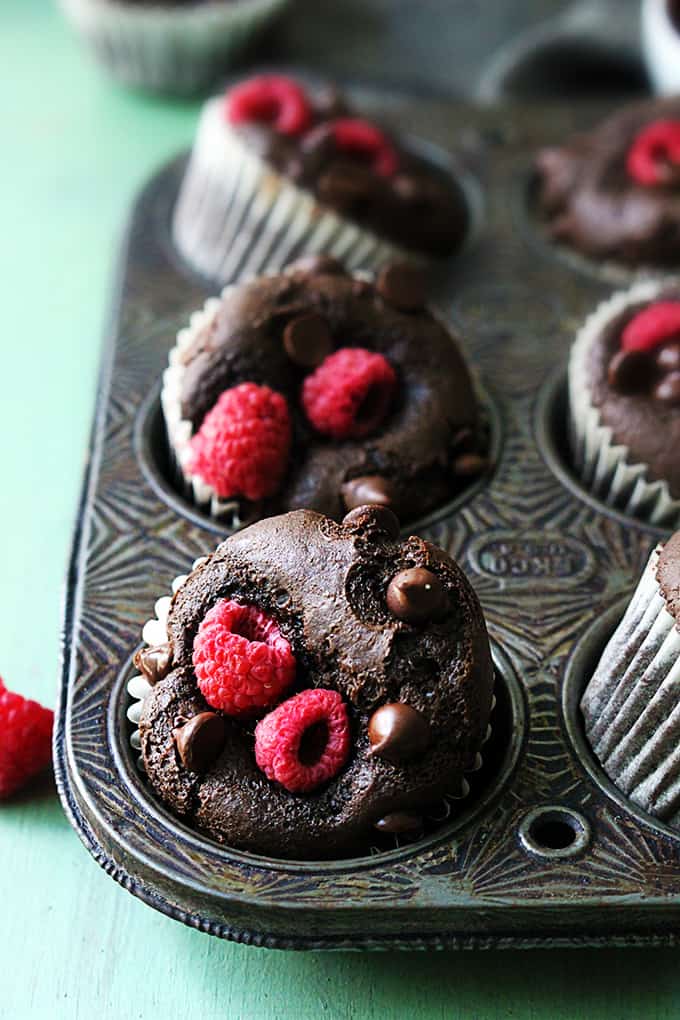 raspberry chocolate muffins in a muffin pan.