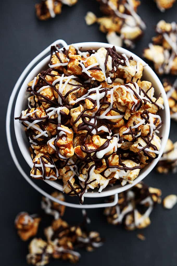 top view of zebra caramel corn in a tin bucket with more popcorn around it.