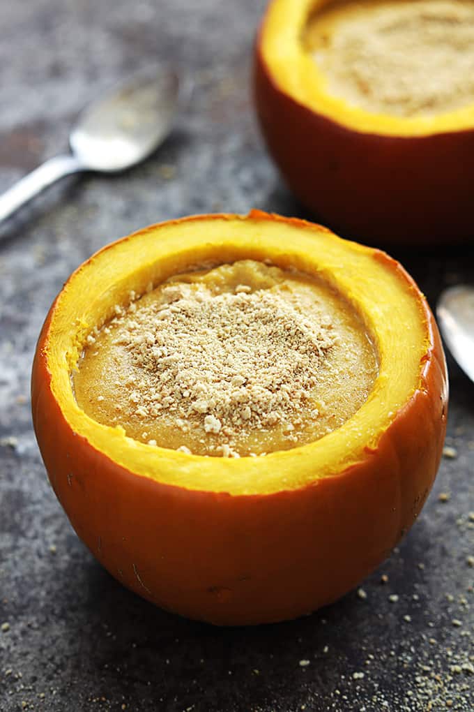 apumpkin cheesecake stuffed pumpkin with spoons and another pumpkin in the background.