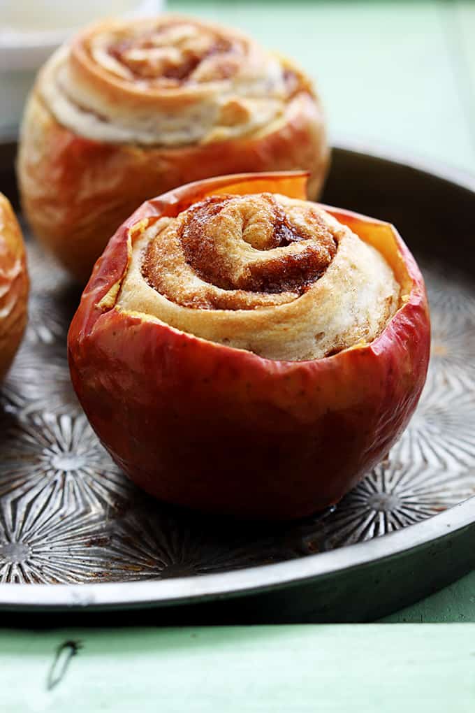 cinnamon roll stuffed baked apples on a serving tray.