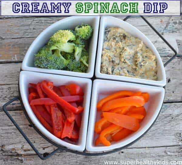 a veggie tray with creamy spinach dip with the title of the recipe written across the top of the image.