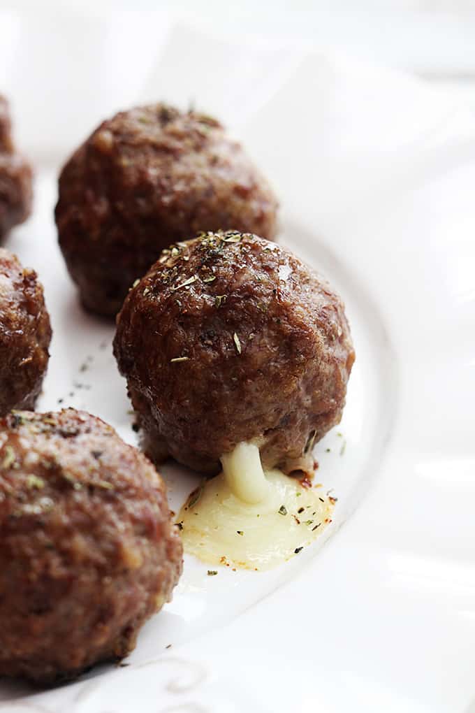 close up of slow cooker mozzarella stuffed meatballs on a plate.