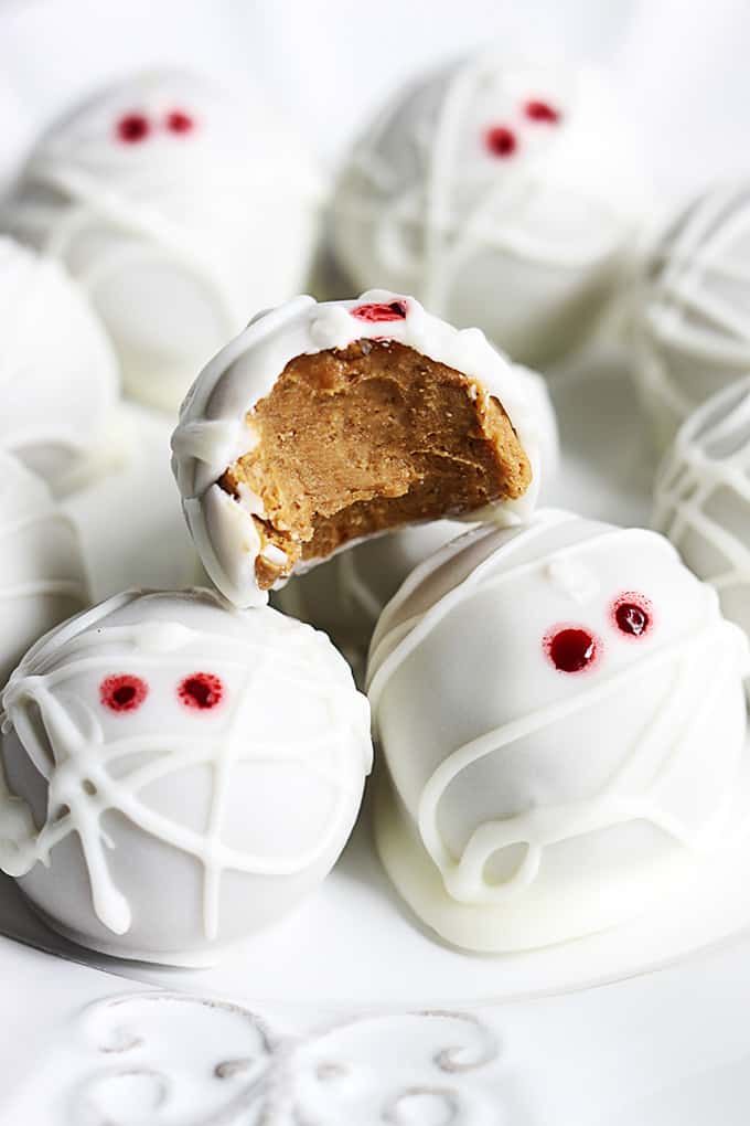 pumpkin cheesecake truffle mummies with one missing a bite out of it.