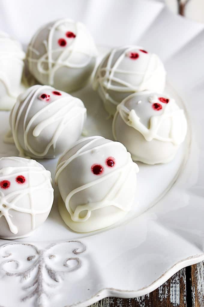 close up of pumpkin cheesecake truffle mummies on a plate.