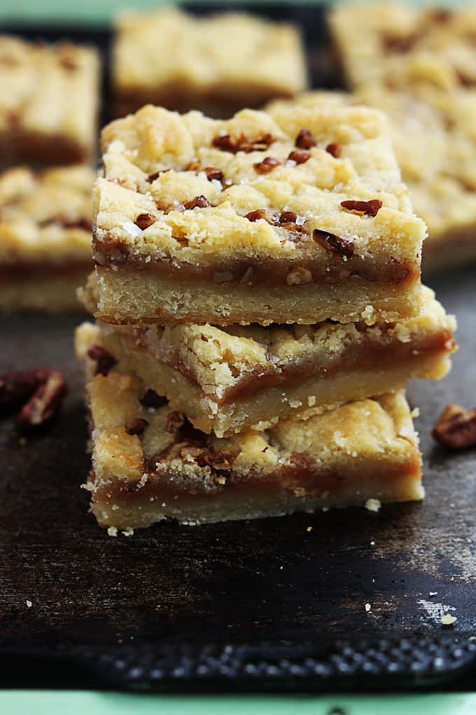 stacked salted caramel pecan butter bars with more bars faded in the background.