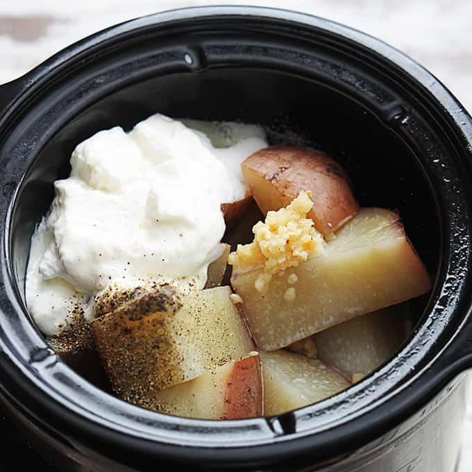 slow cooker mashed potato ingredients uncooked in a slow cooker.