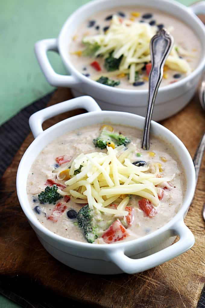 two bowls of southwest broccoli chowder with a spoon being in the front bowl.