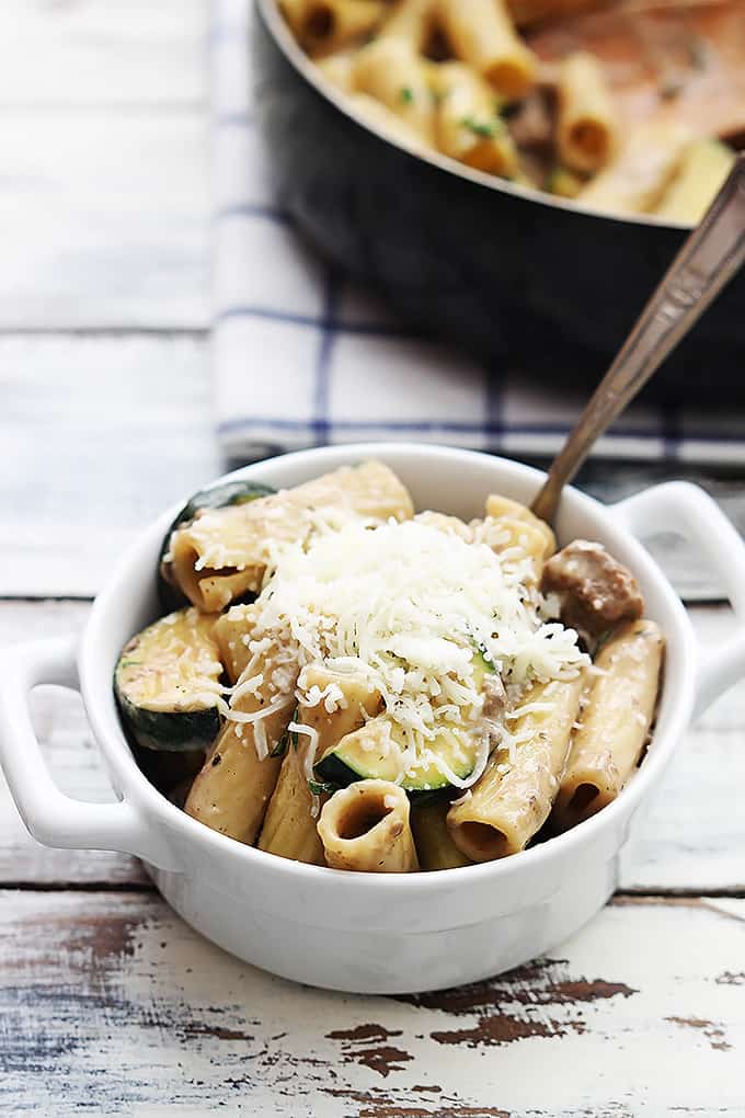a small bowl of speedy sausage rigatoni with more pasta in a skillet.