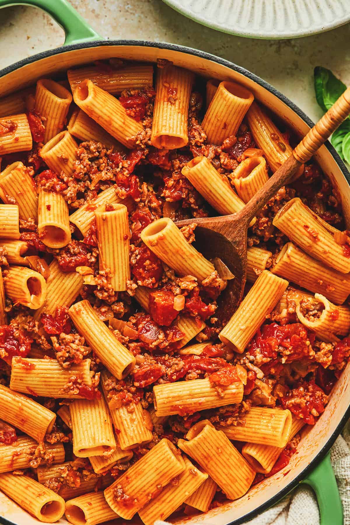 Overhead close up of creamy burrata pasta with sausage in a skillet.