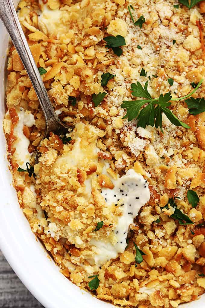 close up top view of poppy seed chicken casserole with a spoon in a serving dish.