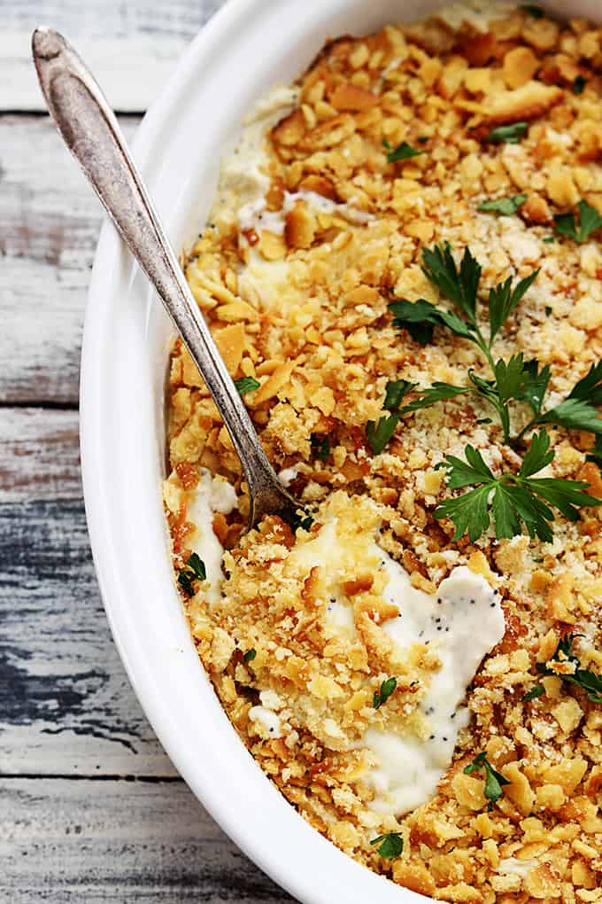 close up of poppy seed chicken casserole with a spoon in a serving dish.