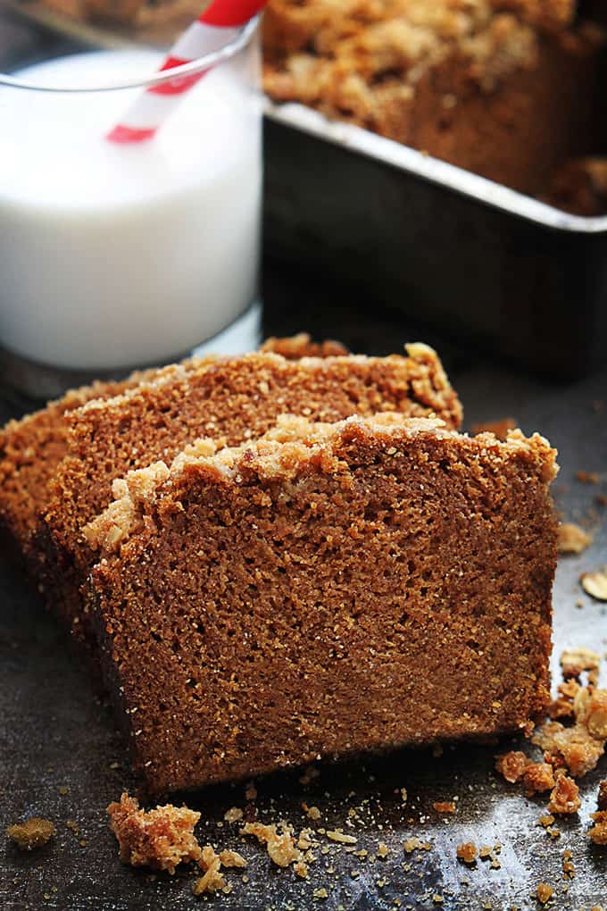 slices of cinnamon streusel pumpkin bread with a glass of milk and the rest of the loaf of bread in the background.