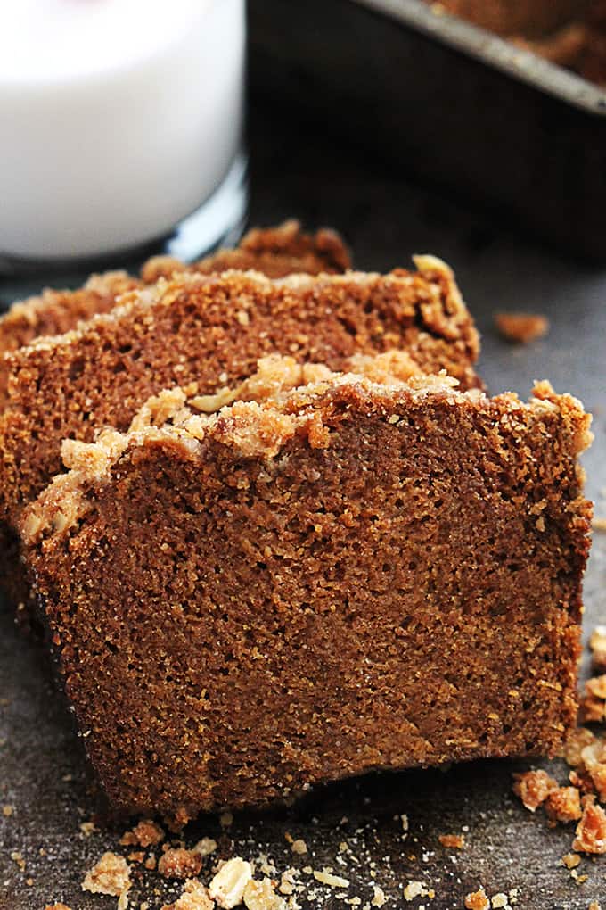 close up of slices of cinnamon streusel pumpkin bread with a glass of milk in the background.