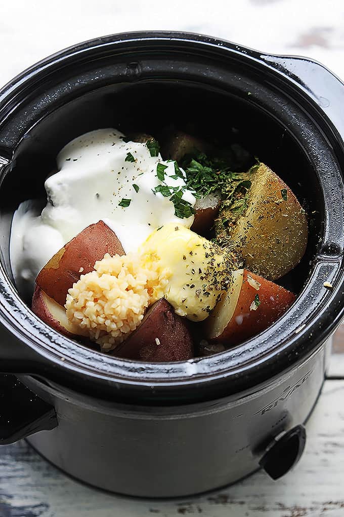 top view of a slow cooker with unmixed raw ingredients.