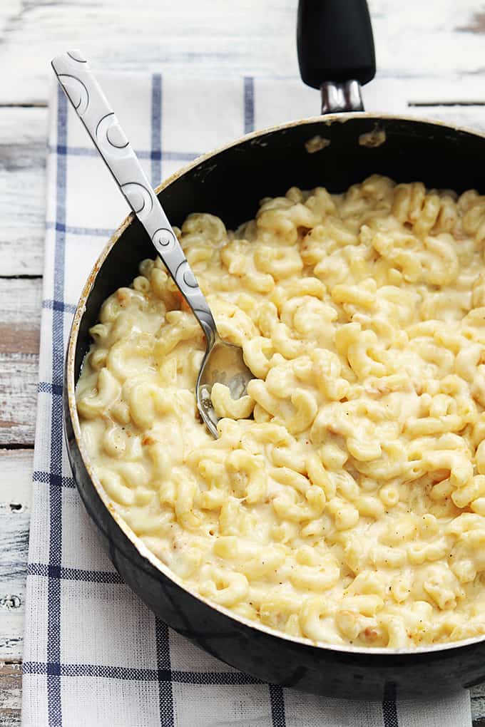 top view of three cheese macaroni with a spoon in a skillet.