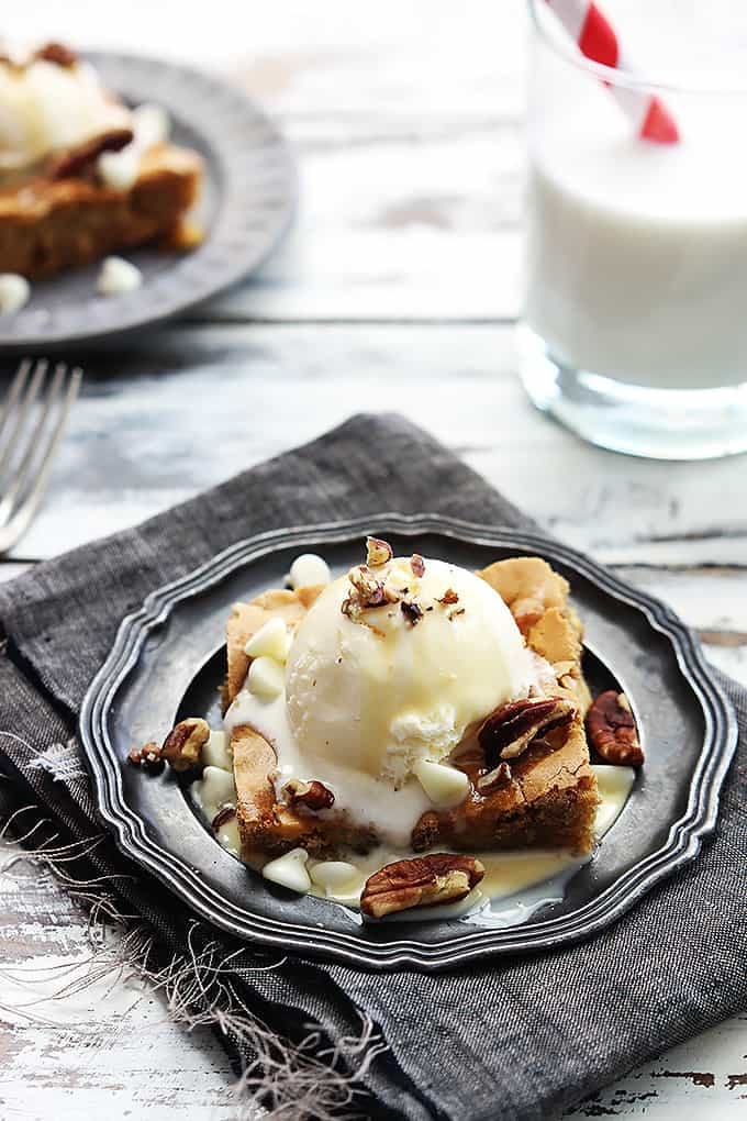 Applebee's maple nut blondie with cream sauce on a plate with a glass of milk on the side.