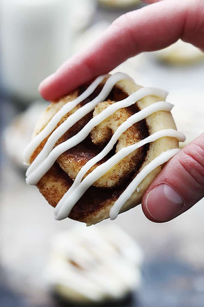 a hand holding a cinnamon roll cookie.