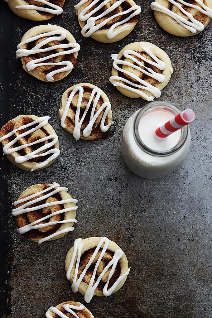 top view of cinnamon roll cookies with a glass bottle of milk with a straw. 