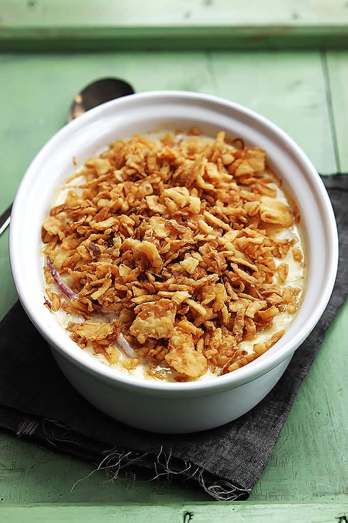 French onion scalloped potatoes topped with crunchy onions in a serving dish.