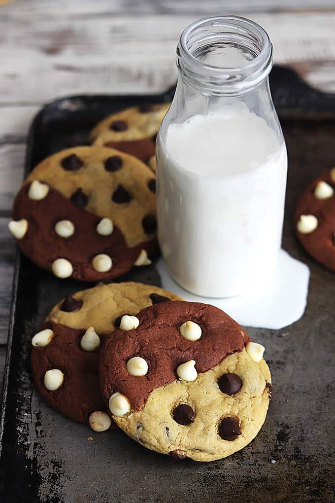 true love cookies (aka: brookies)  on a baking sheet surrounding a glass jar of milk on top of a milk puddle.