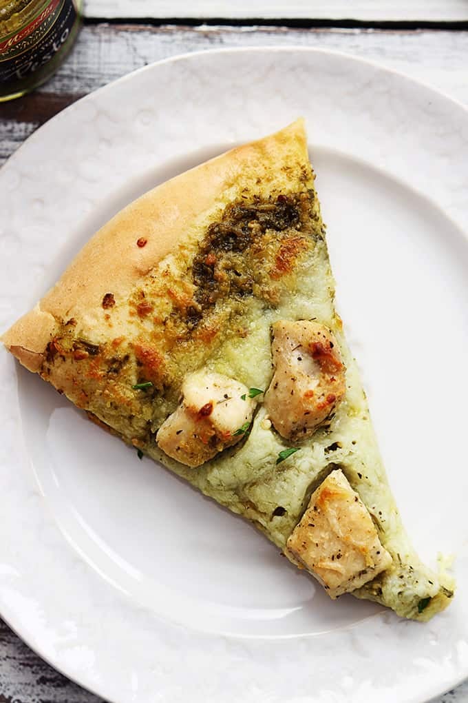top view of a slice of pesto chicken pizza on a plate.