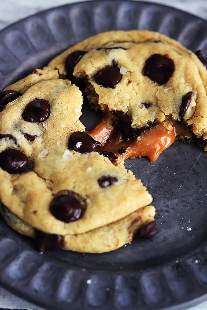a salted caramel chocolate chip cookie split in half on a plate.