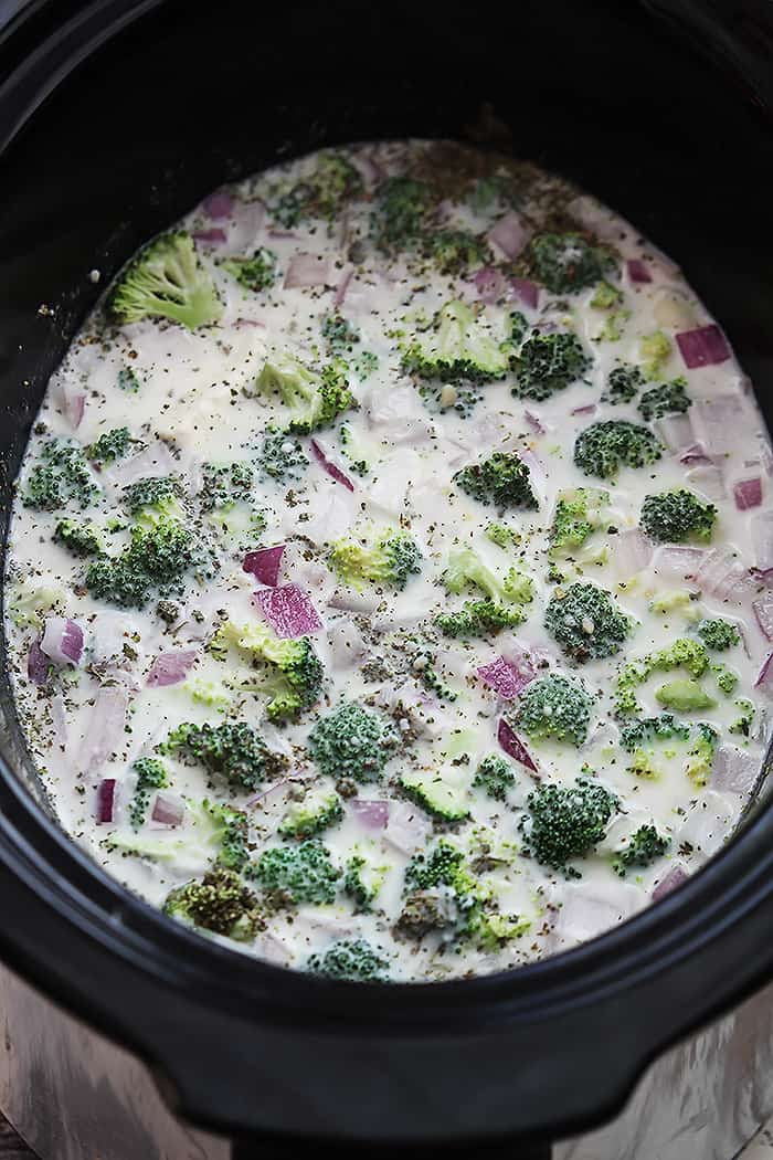 top view of slow cooker broccoli cheese soup ingredients mixed together in a slow cooker.