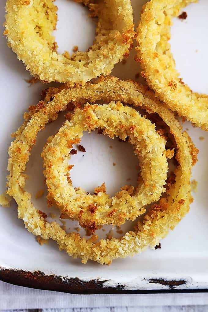 close up top view of onion rings on a baking sheet.