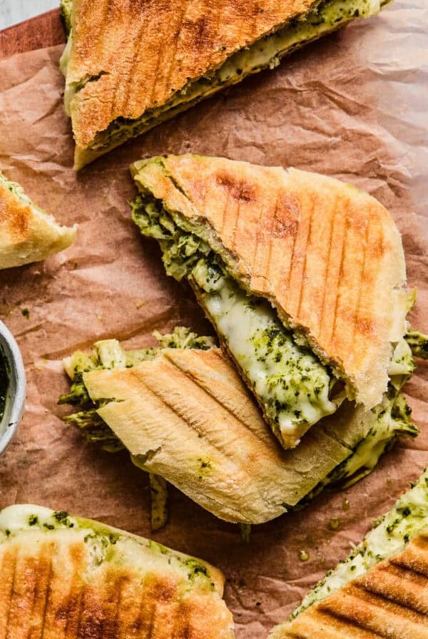 overhead view of chicken pesto panini sandwich cut in half.