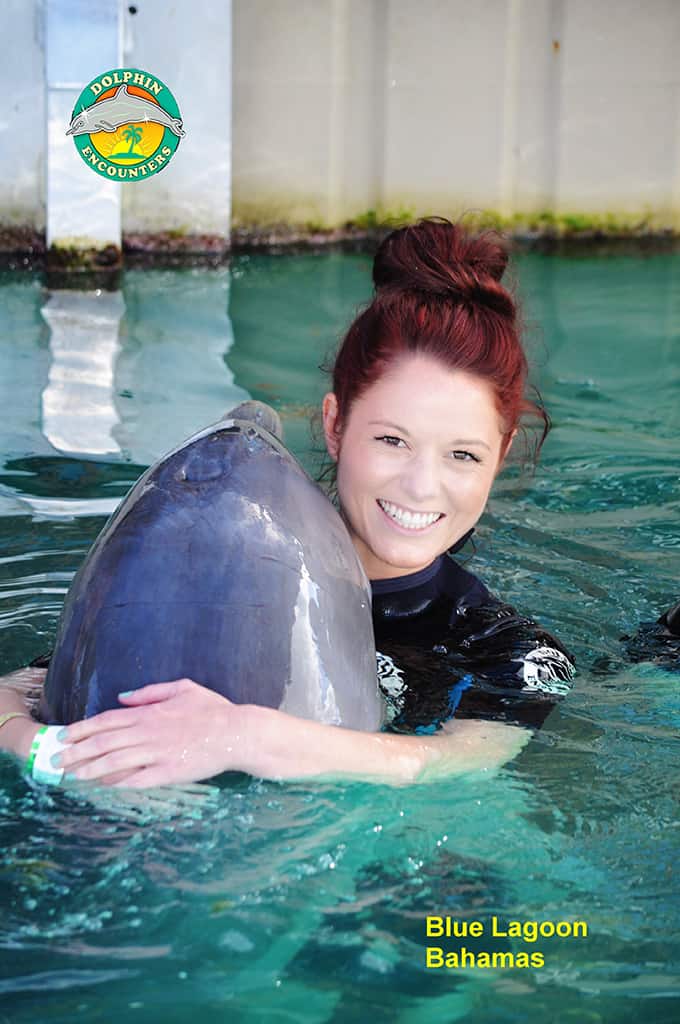 Tiffany hugging a dolphin.