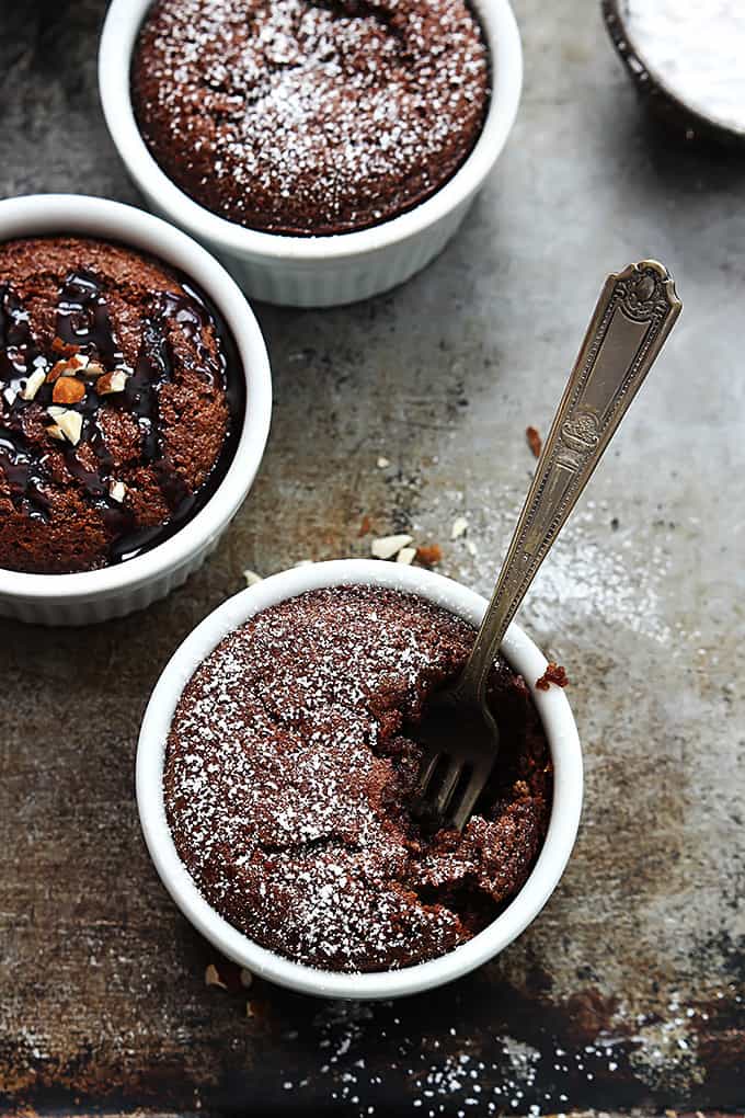 top view of flourless chocolate almond cakes in small individual bowls with a fork in one of the bowls.